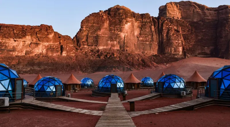 A row of blue bubble domes and Bedouin tents at a Wadi Rum desert camp